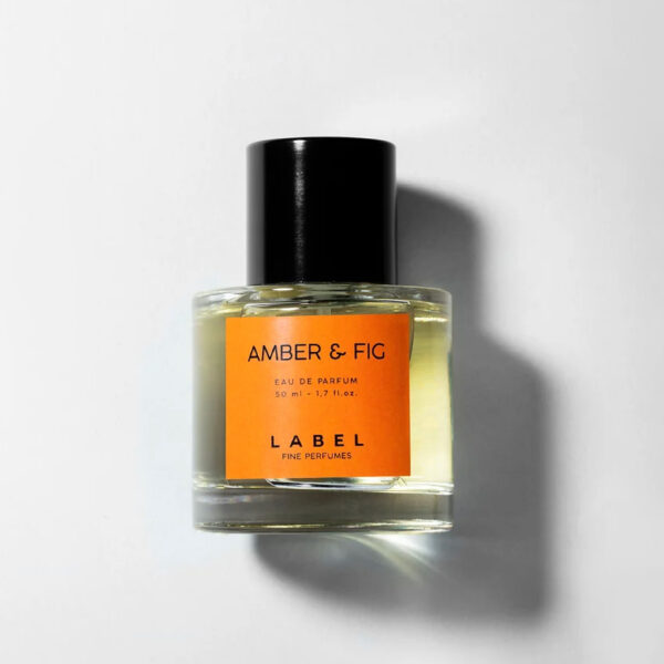 Perfume cilíndrico ámbar, tapa negra, Amber & Fig en letras negras.