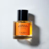 Perfume cilindrico, tapa negra, Amber and Rosewood en letras negras.