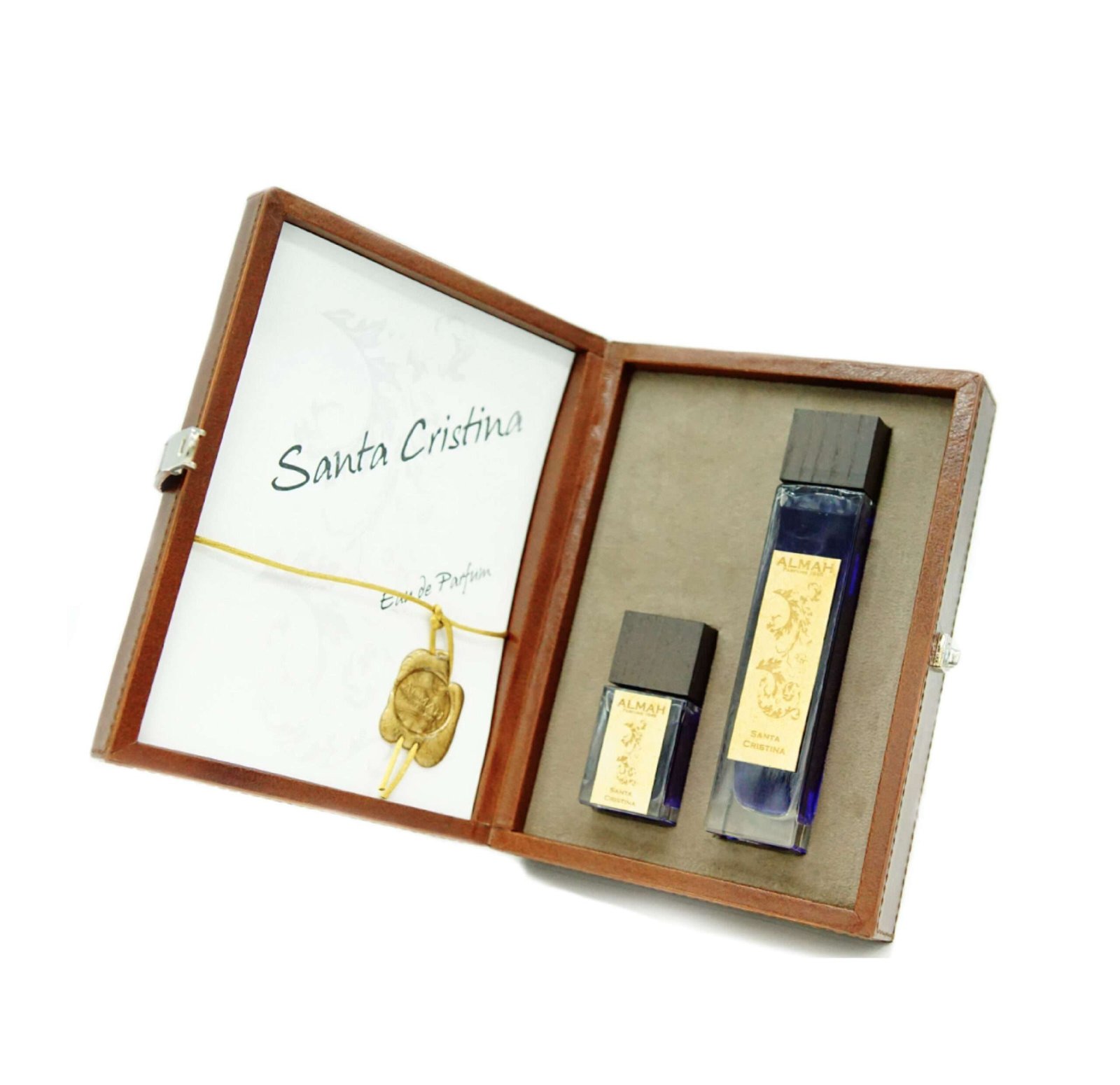 Perfumes en estuche marrón, envases rectangulares, líquido azul, tapa negra, etiqueta dorada. Santa Cistina en tarjeta blanca.